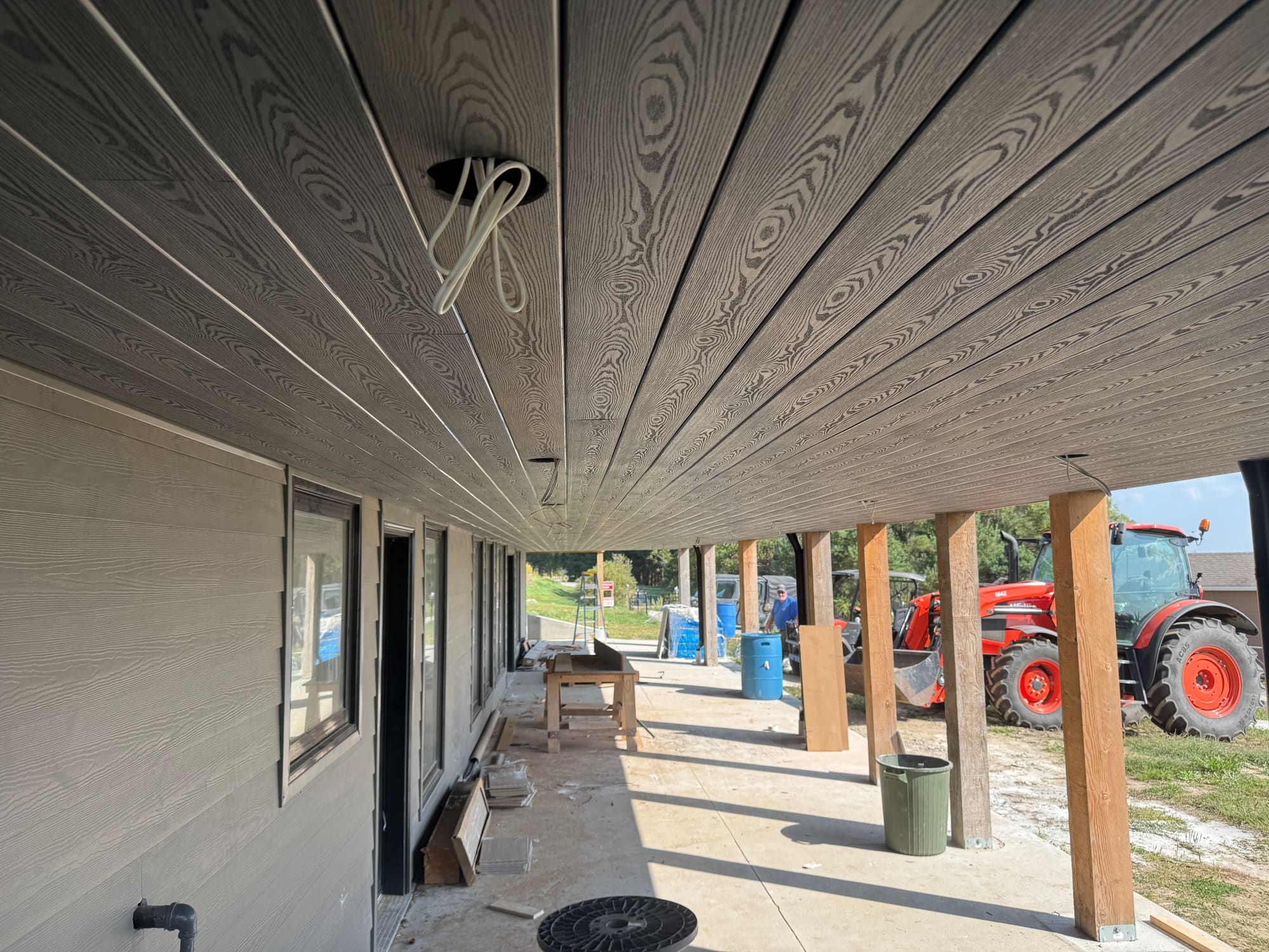 Charcoal SoffiWood ceiling running the full length of the walkout patio under a raised deck in Oshawa, Ontario